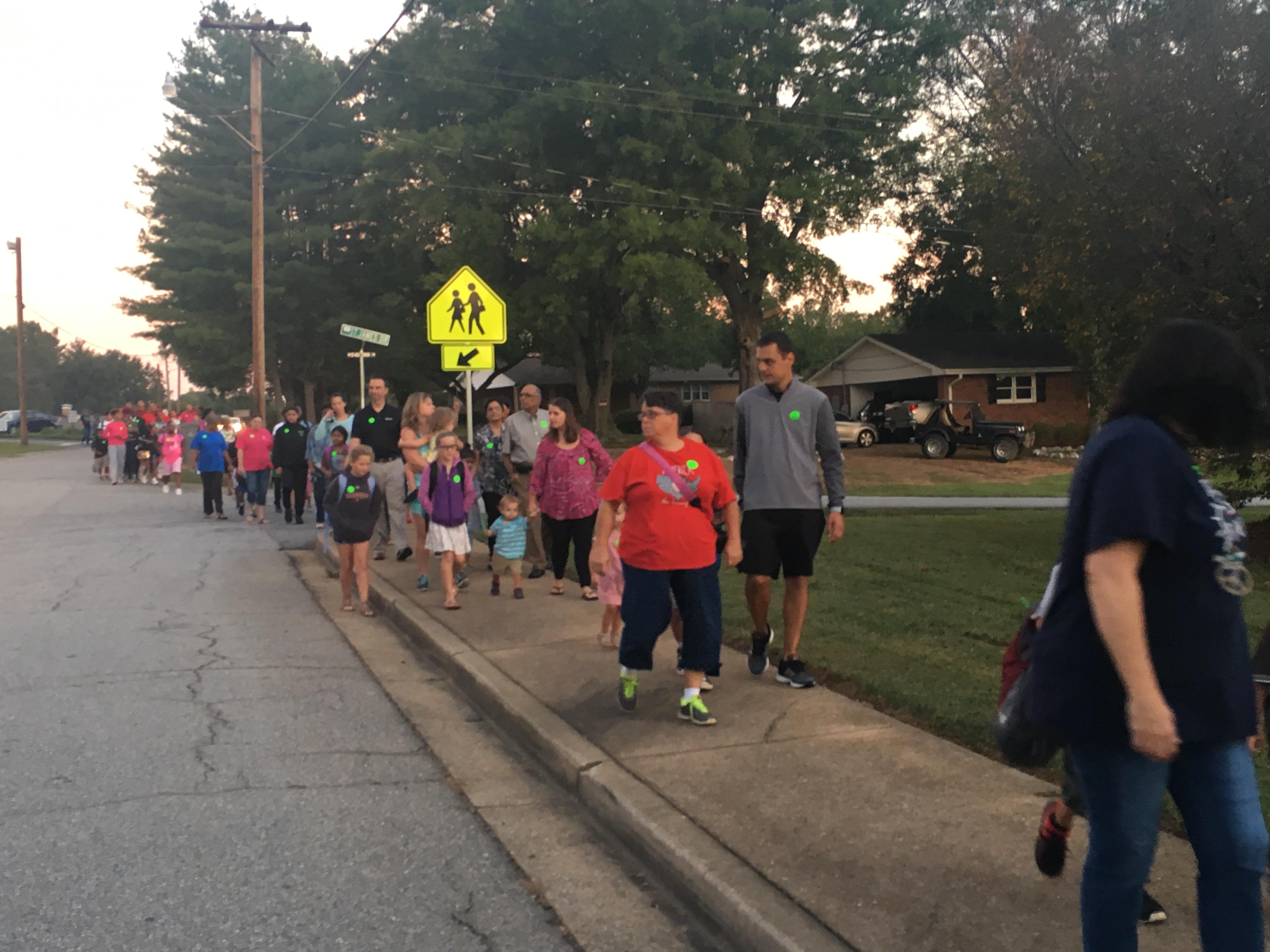 Family members walk to school with their children